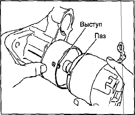 а) Совместите паз в корпусе стартера с выступом амортизатора.